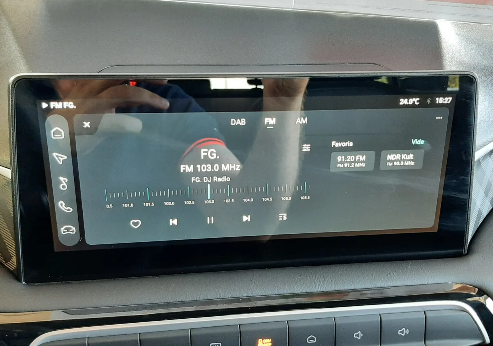 Écran tactile central de la MG3 2026 affichant la radio FM sur fond noir, avec commandes climatisation en dessous.