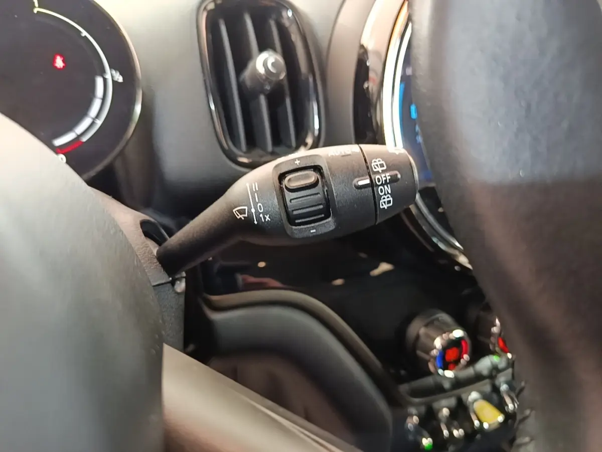 Gros plan sur la commande d’essuie-glace côté gauche du tableau de bord noir du MINI Countryman gris clair hybride rechargeable.