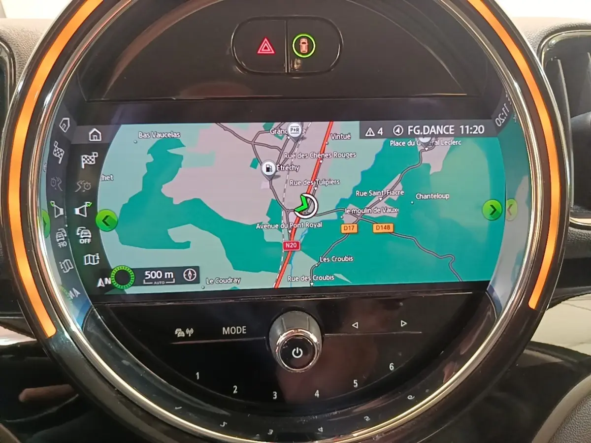Vue rapprochée de l'écran tactile central du MINI Countryman gris clair affichant la navigation avec anneau lumineux orange.