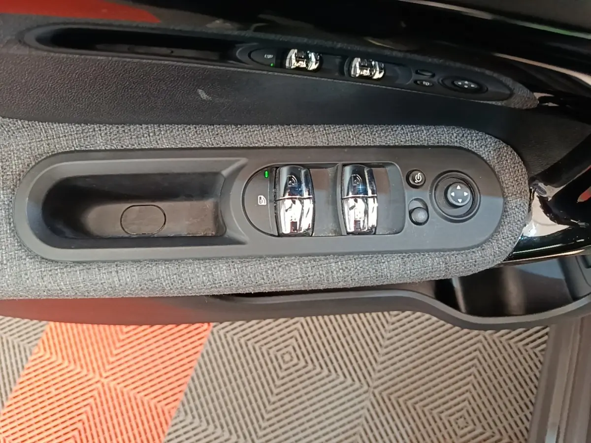 Gros plan sur la commande des vitres et rétroviseurs côté conducteur du MINI Countryman gris clair 2021.