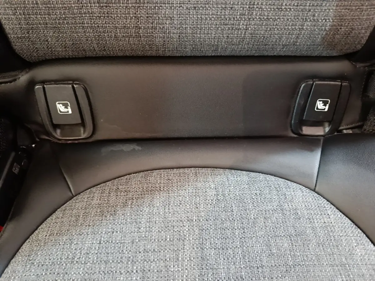 Détail des fixations ISOFIX sur siège arrière en tissu gris clair du MINI Countryman hybride rechargeable.