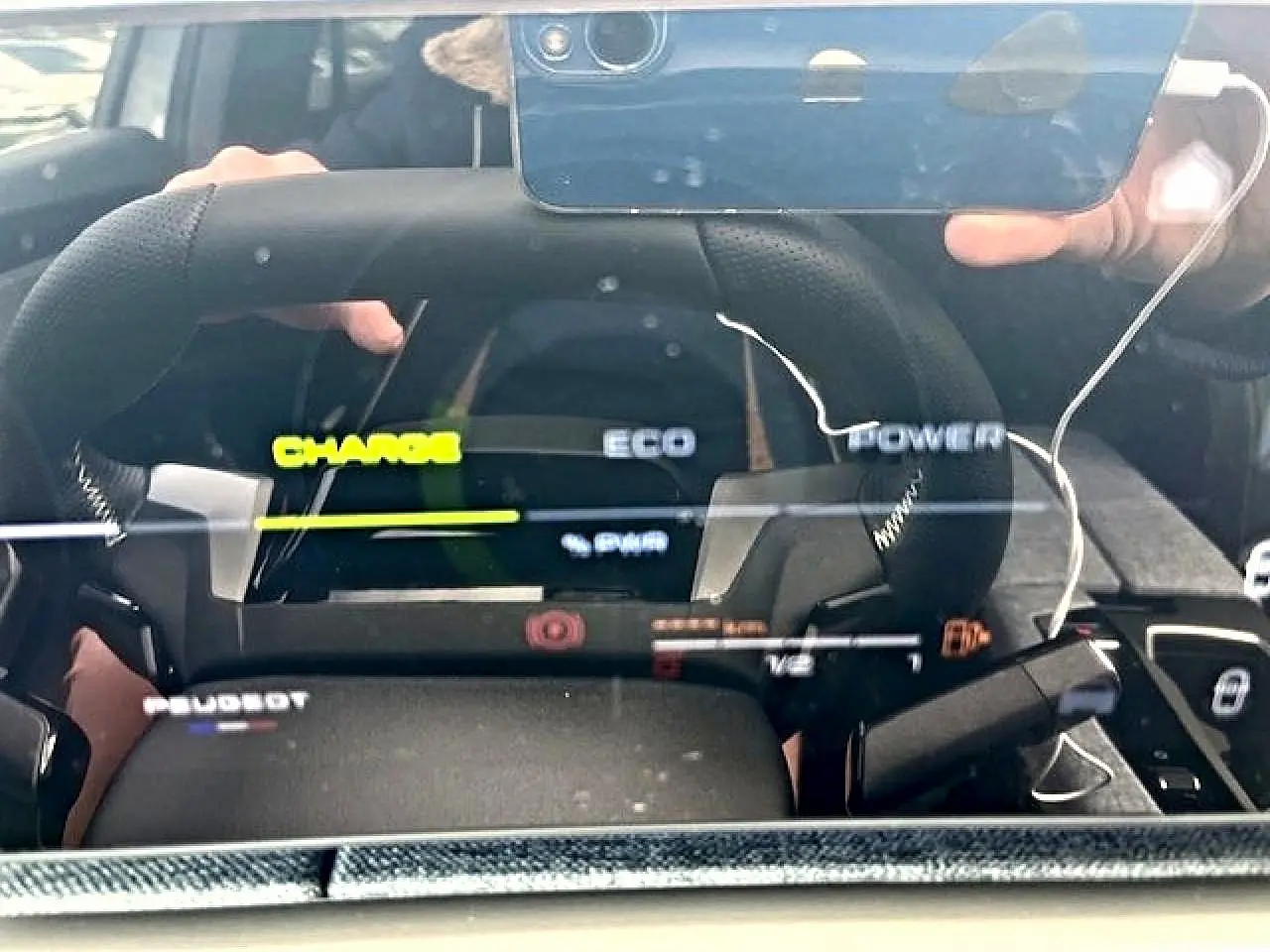 Vue rapprochée du tableau de bord numérique et volant cuir noir du Peugeot 3008 gris Artense hybride 2025.