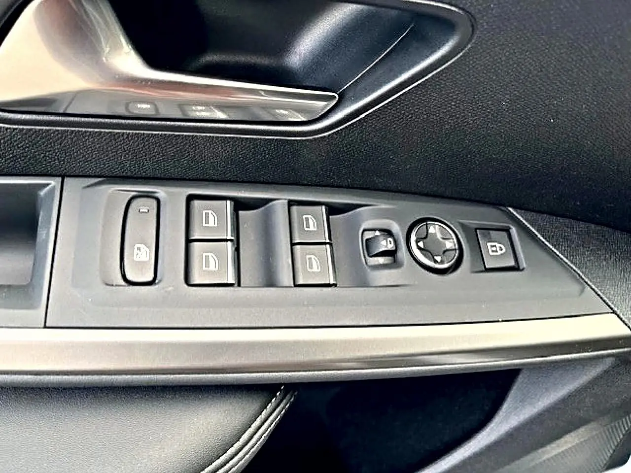 Gros plan sur les commandes de vitres et rétroviseurs côté gauche intérieur du Peugeot 3008 gris Artense 2025.