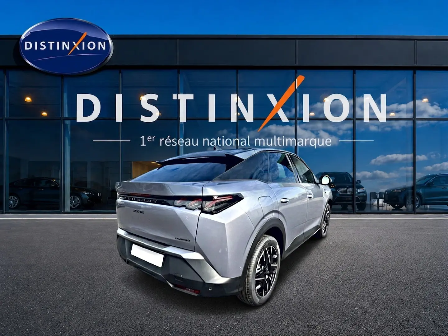 Vue 3/4 arrière droite du Peugeot 3008 gris Artense avec jantes noires devant un showroom Distinxion.
