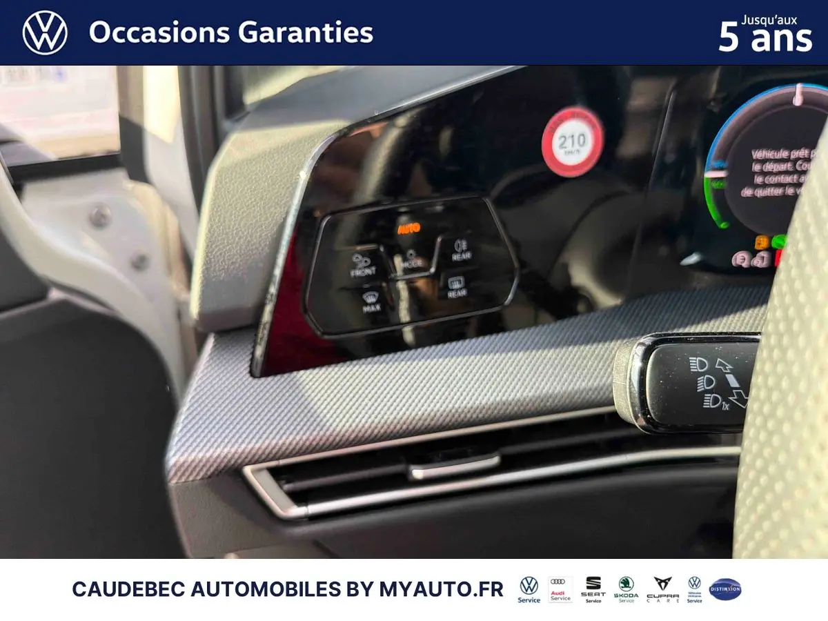 Détail du tableau de bord côté gauche de la Volkswagen Golf 1.5 eHybrid 2025 avec commandes de climatisation et volant partiellement visible.