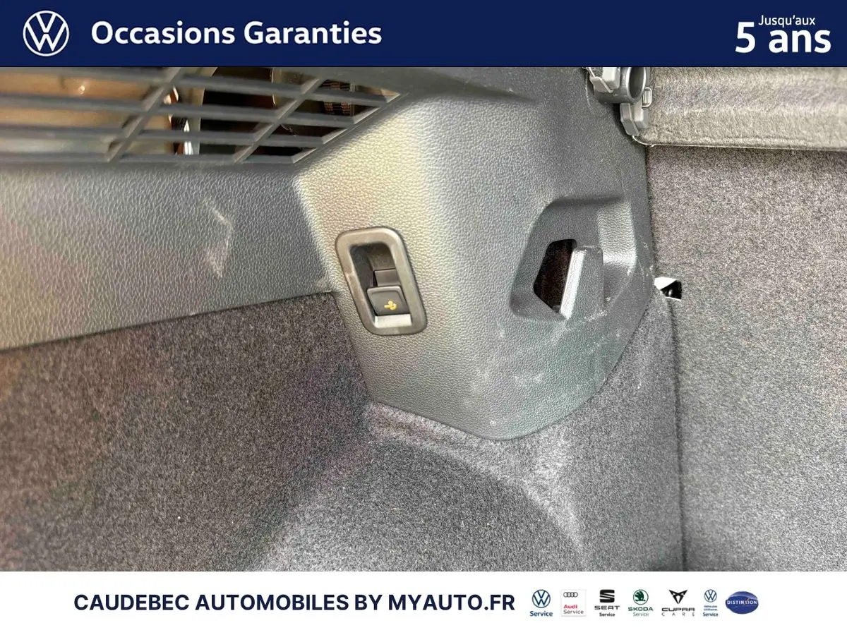 Détail intérieur du coffre arrière de la Volkswagen Golf 1.5 eHybrid 2025, montrant un crochet d’arrimage côté droit.