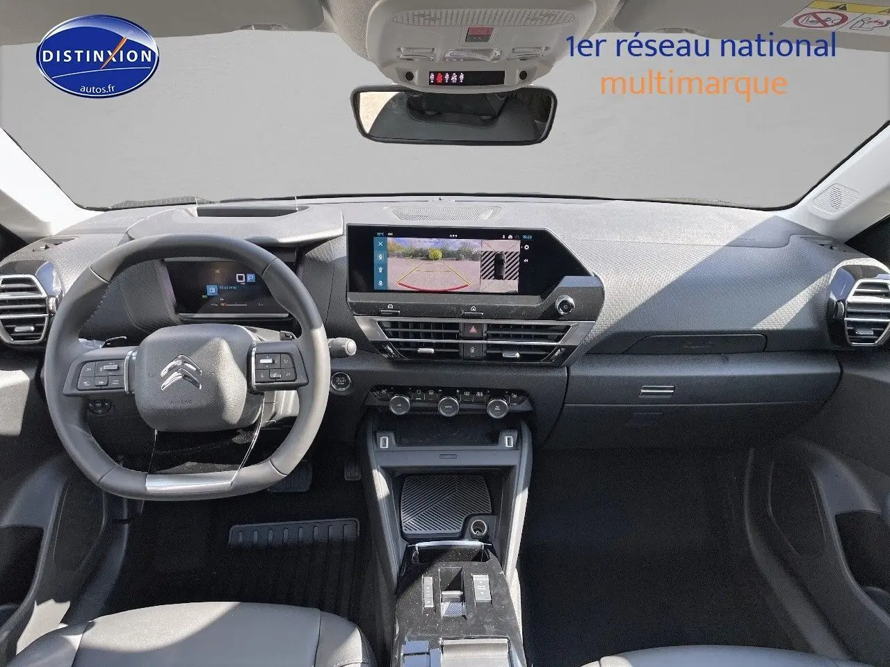 Intérieur de la Citroën C4 2024 gris platinium, vue frontale du tableau de bord avec écran tactile et volant multifonction.