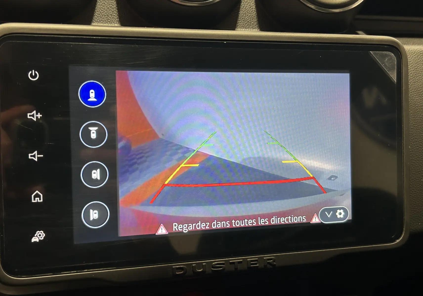 Écran de caméra de recul du Dacia Duster orange Arizona 2022, avec lignes de guidage colorées visibles.