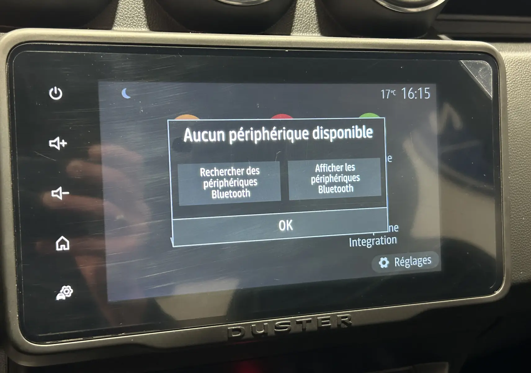 Écran tactile central du Dacia Duster 2022 affichant un message Bluetooth, entouré de commandes et de la console noire.