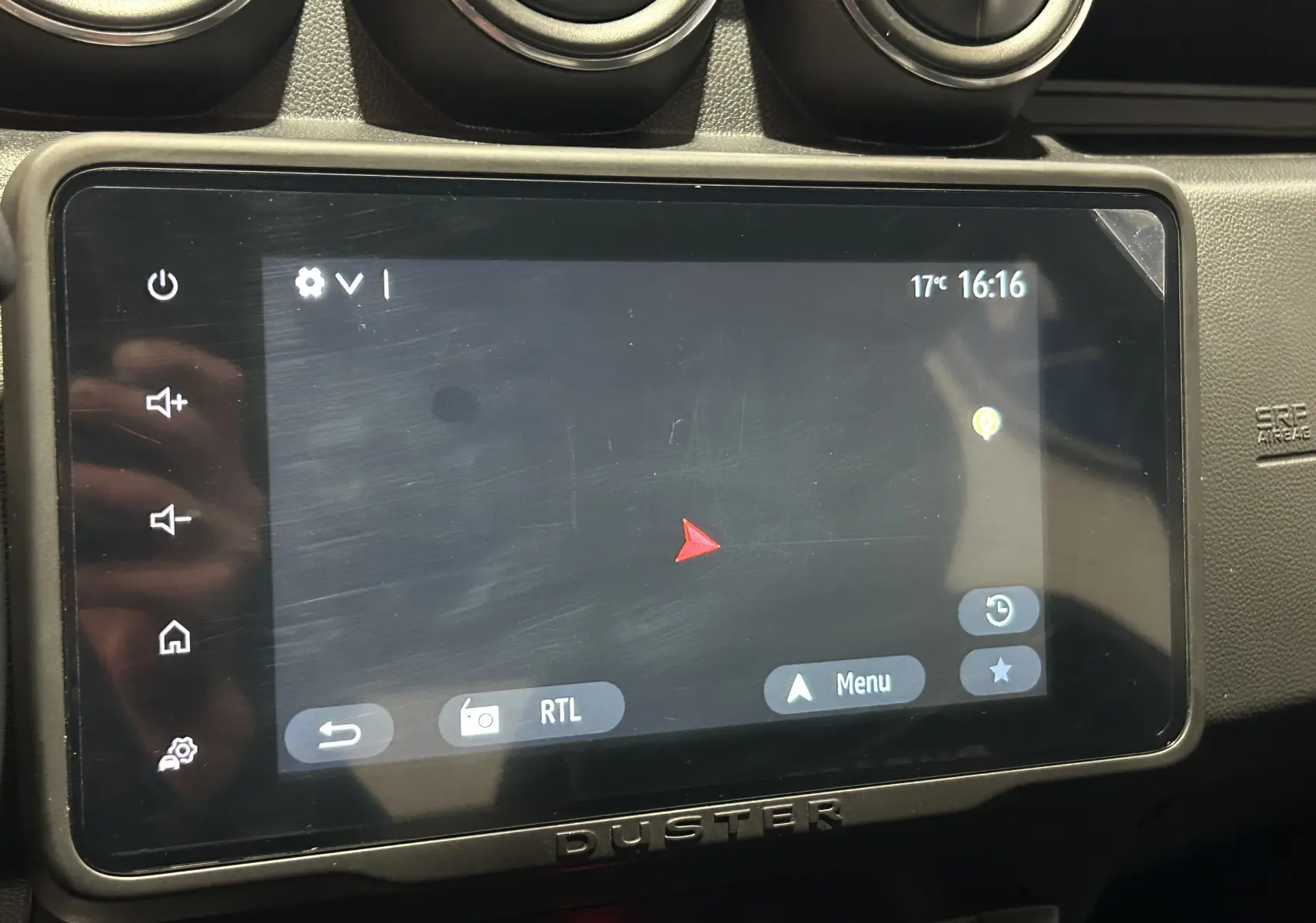 Écran tactile central du Dacia Duster 2022 affichant la navigation, entouré de commandes et aérateurs noirs.