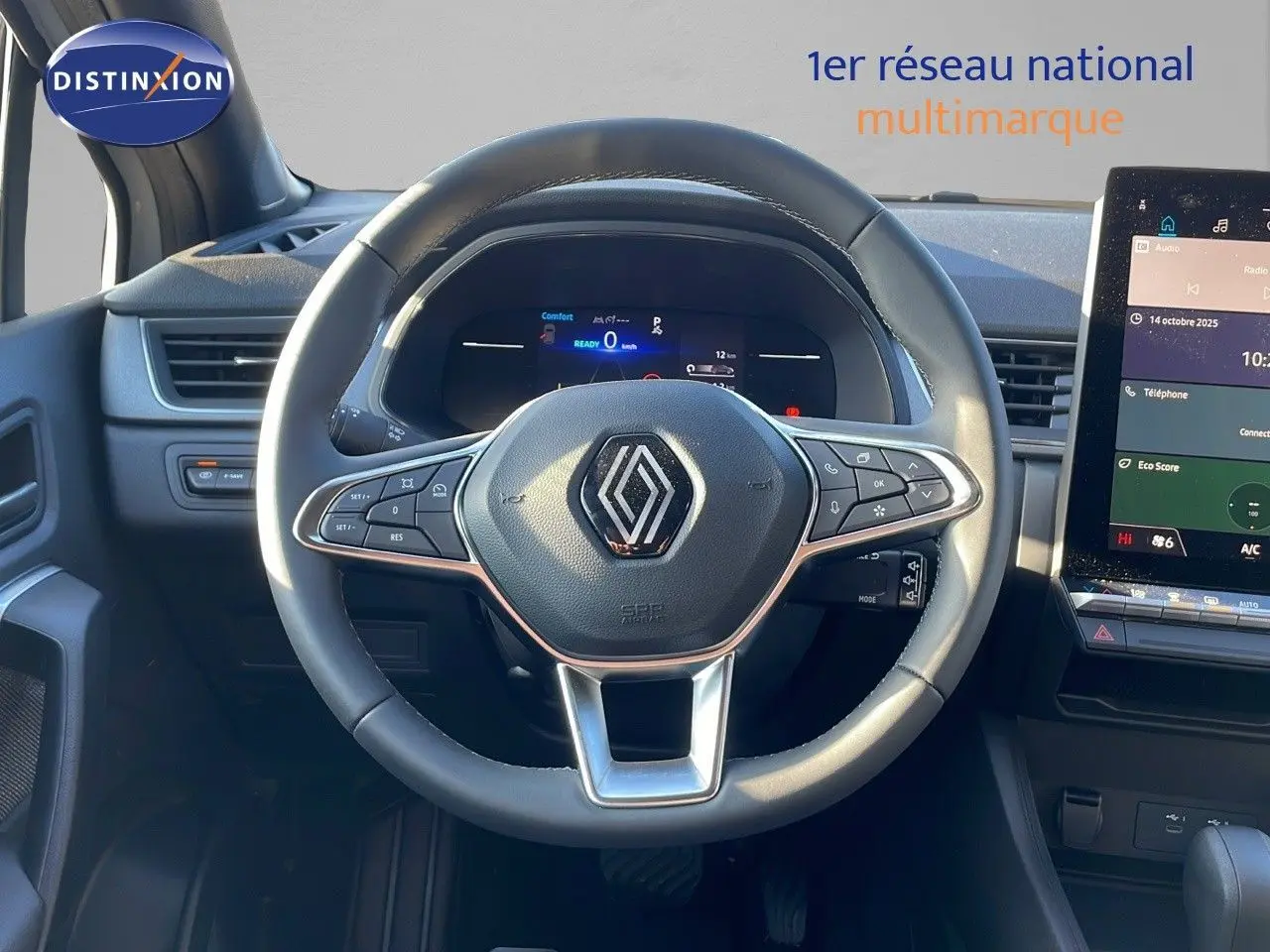 Vue intérieure centrée sur le volant Renault Captur E-Tech gris rafale, tableau de bord digital et écran tactile visible.