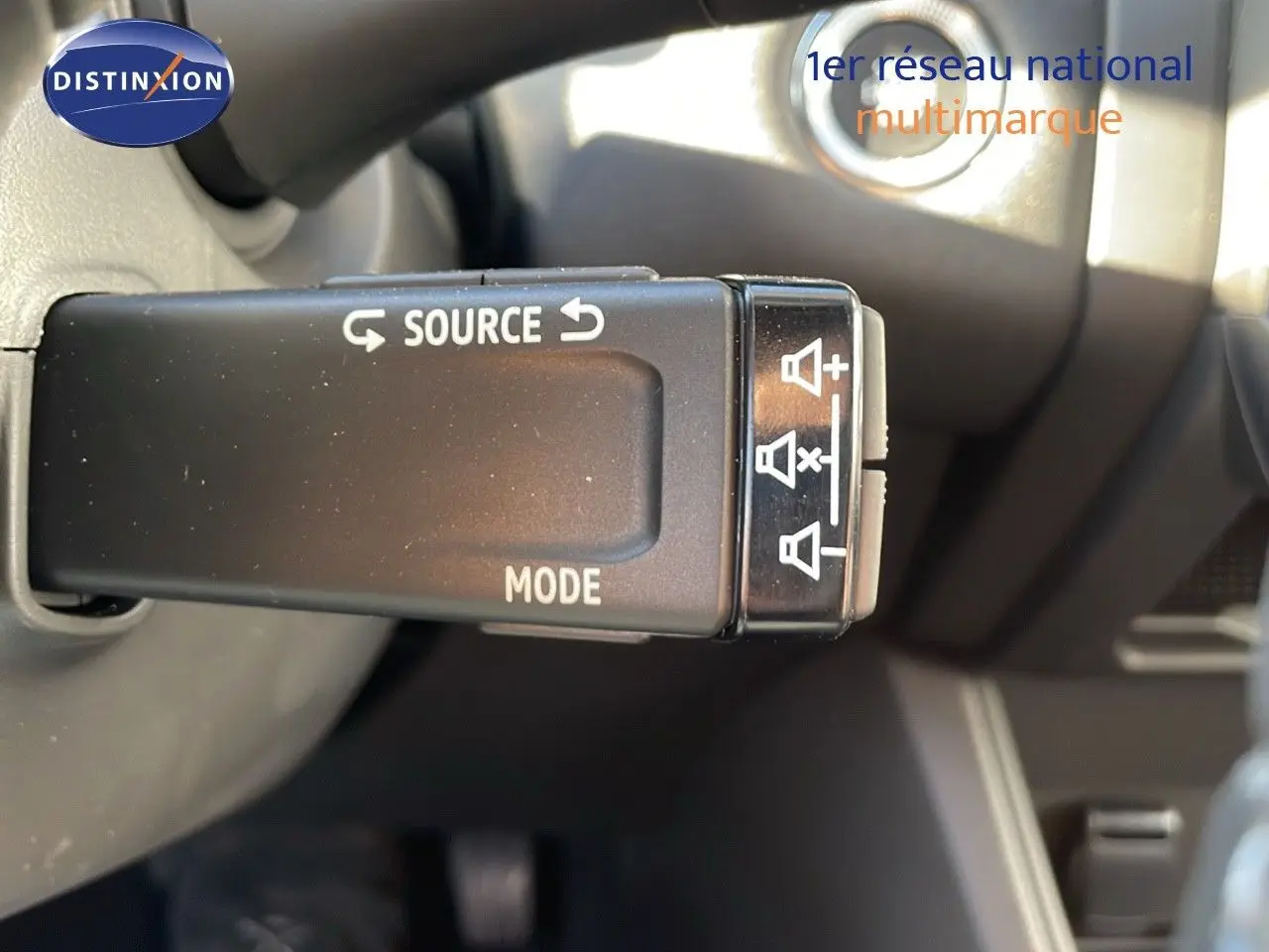 Gros plan sur la commande de source audio au volant du Renault Captur E-Tech gris Rafale métal avec toit noir.