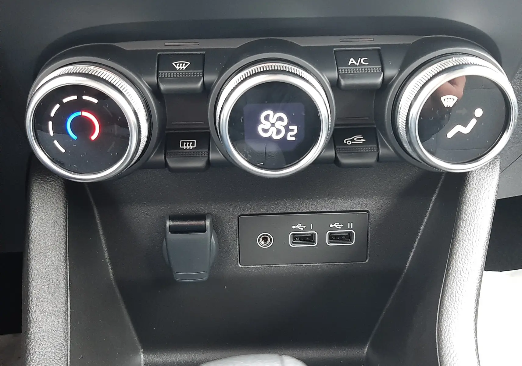 Vue rapprochée des commandes de climatisation et des ports USB de la Renault Clio V E-Tech gris schiste.