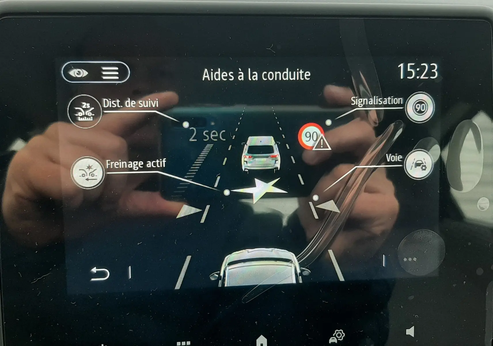 Écran tactile intérieur de la Renault Clio V gris schiste montrant l’aide à la conduite avec suivi de distance et signalisation.