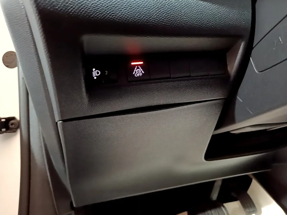 Détail intérieur du tableau de bord côté conducteur de la Peugeot 208 électrique Active Business 2021, bouton d'alerte franchissement de ligne activé.