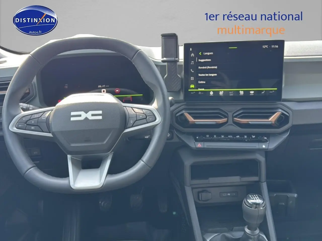 Vue intérieure frontale du tableau de bord gris et noir du Dacia Bigster 2026 avec volant multifonction et écran tactile central.