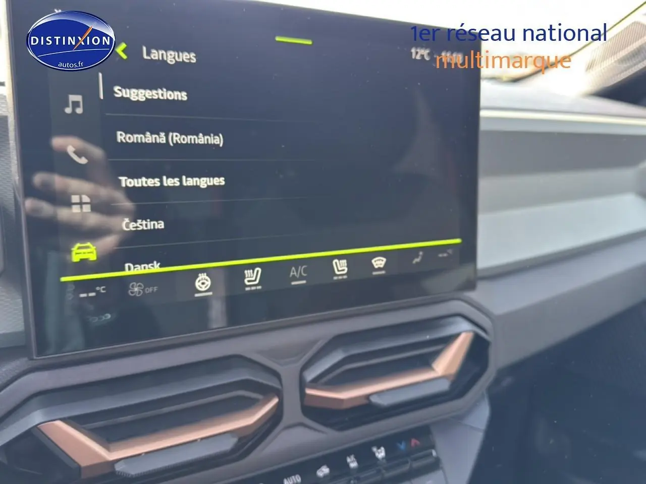 Détail de l’écran tactile et des aérateurs cuivrés du tableau de bord du Dacia Bigster gris schiste, vue intérieure frontale.