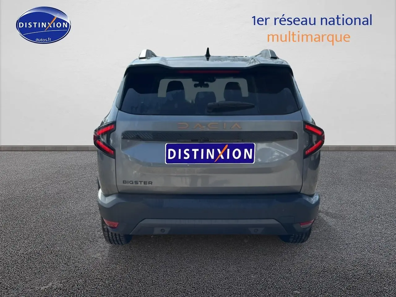 Vue arrière du Dacia Bigster gris schiste avec feux LED en forme de C et hayon électrique visible.