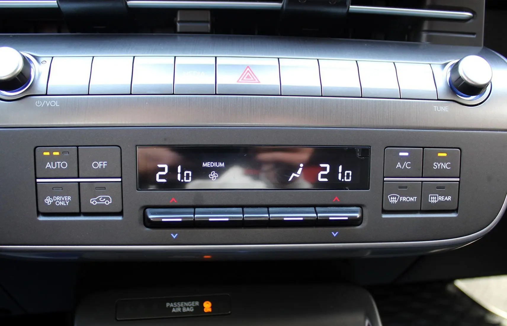 Vue rapprochée du tableau de bord de la Hyundai Kona 2024, affichant la climatisation digitale à 21°C.