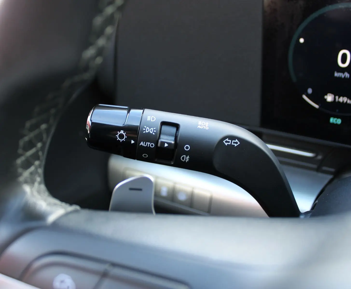 Gros plan sur la commande des feux et clignotants à gauche du volant dans un Hyundai Kona 2024 hybride.