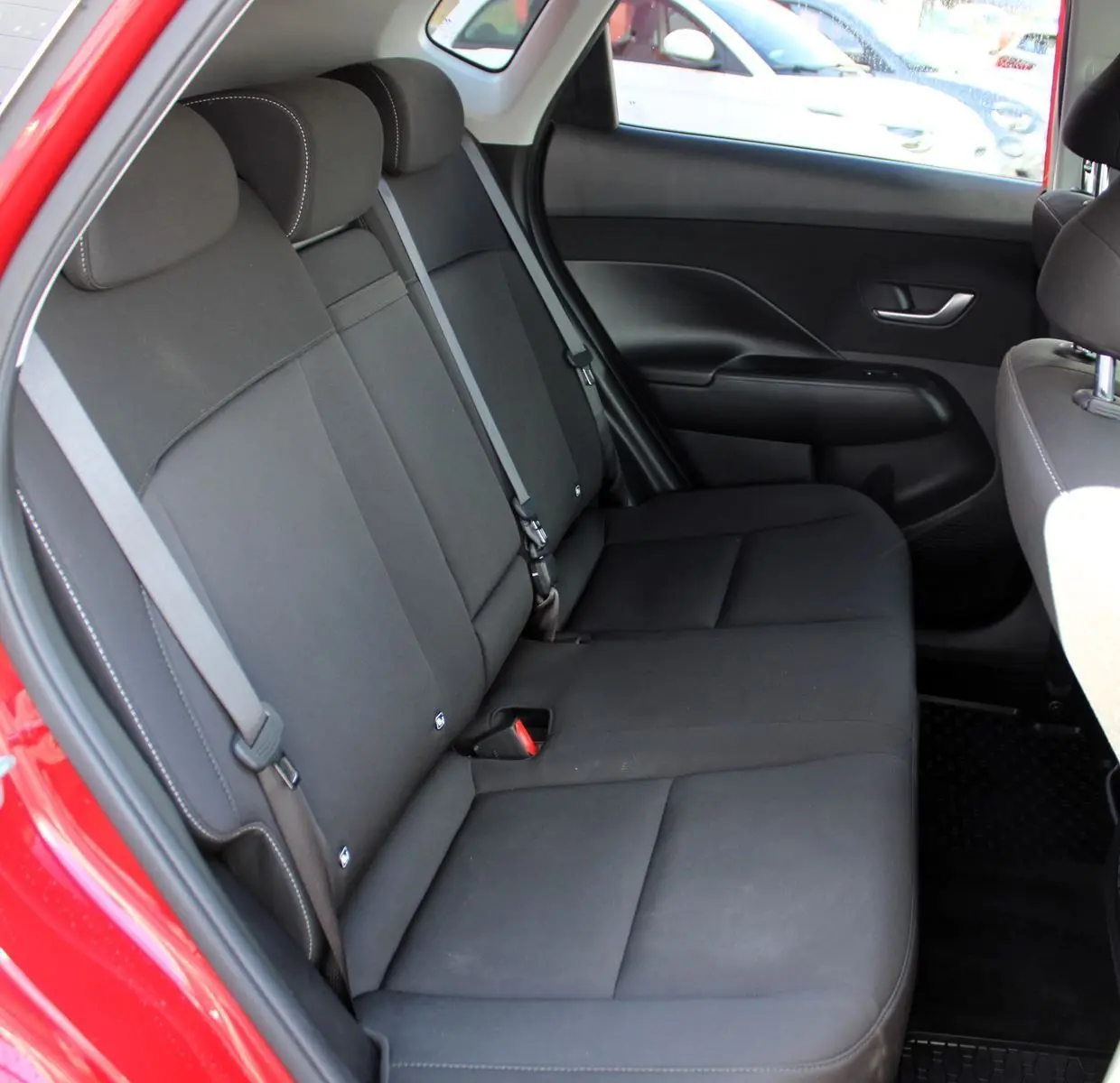 Vue intérieure côté droit des sièges arrière noirs en tissu du Hyundai Kona rouge Ultimate Metal 2024.
