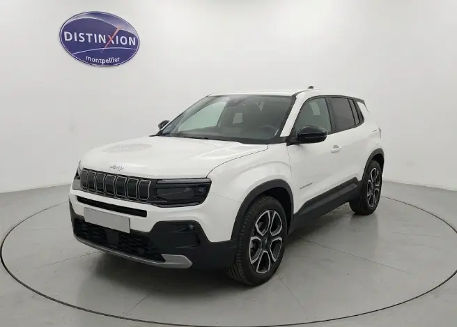 Jeep Avenger blanc en 3/4 avant droit, avec calandre noire et jantes alliage distinctives, dans un studio lumineux.