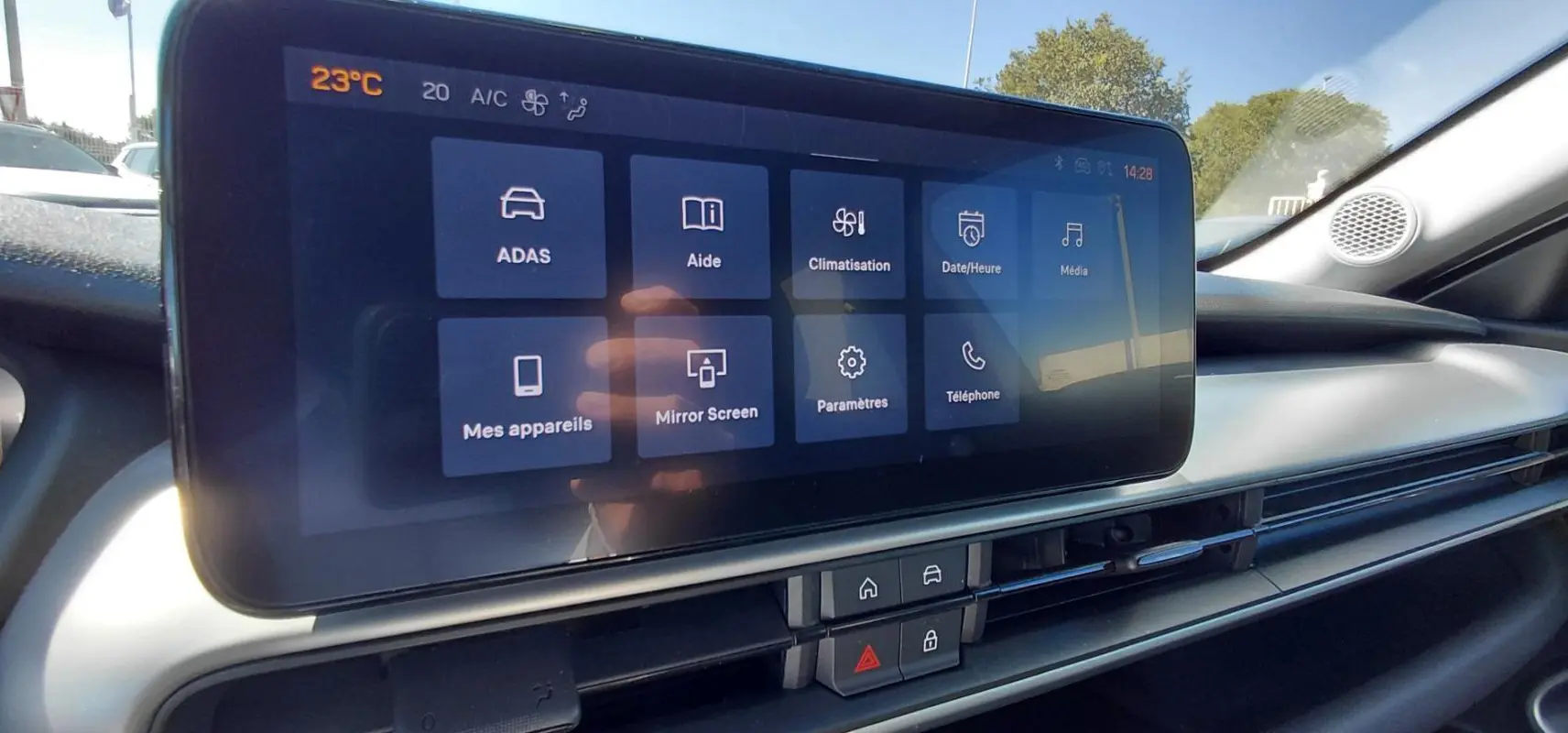 Écran tactile central du tableau de bord du Jeep Avenger blanc 2025, affichant les options de climatisation et connectivité.