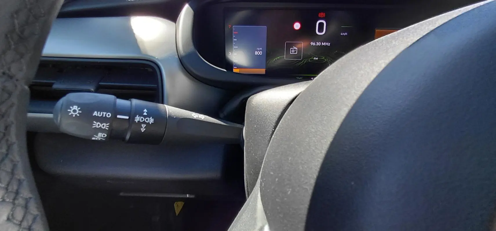 Vue rapprochée du combiné d'instruments numérique et du commodo gauche du Jeep Avenger blanc 2025, version Summit.