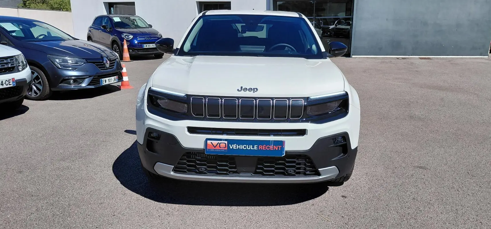 Vue frontale d'un Jeep Avenger blanc 2025 avec calandre noire distinctive et plaque "Véhicule récent".