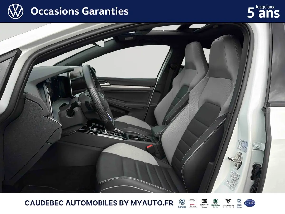 Intérieur de la Volkswagen Golf 1.5 eHybrid blanche, vue côté conducteur, sièges sport bicolores et toit ouvrant panoramique.