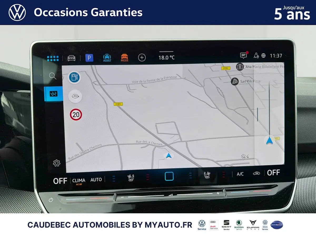 Écran tactile central affichant la navigation GPS dans l'habitacle d'une Volkswagen Golf blanche, vue intérieure.