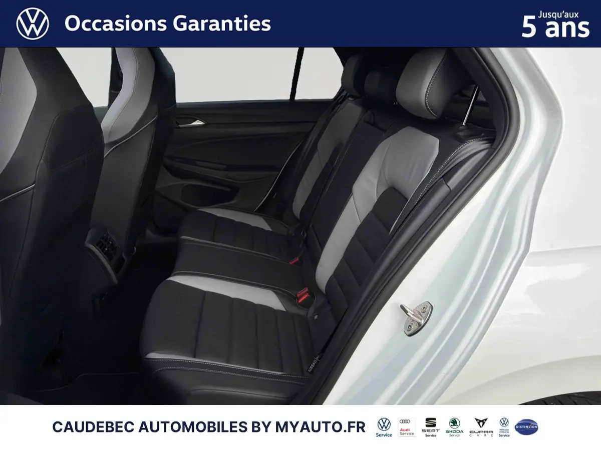 Vue intérieure côté droit des sièges arrière cuir bicolores noir et gris d'une Volkswagen Golf 1.5 eHybrid blanche 2025.