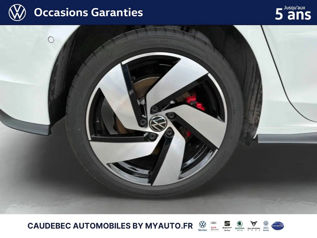 Gros plan sur la roue arrière droite d'une Volkswagen Golf 1.5 eHybrid blanche avec jante alliage Richmond noire et argent.
