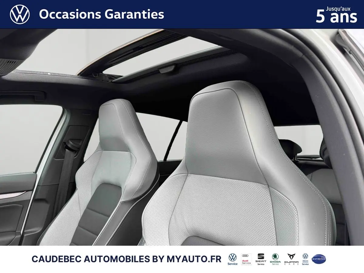 Vue intérieure des sièges avant cuir gris clair de la Volkswagen Golf 1.5 eHybrid 2025 avec toit ouvrant panoramique.