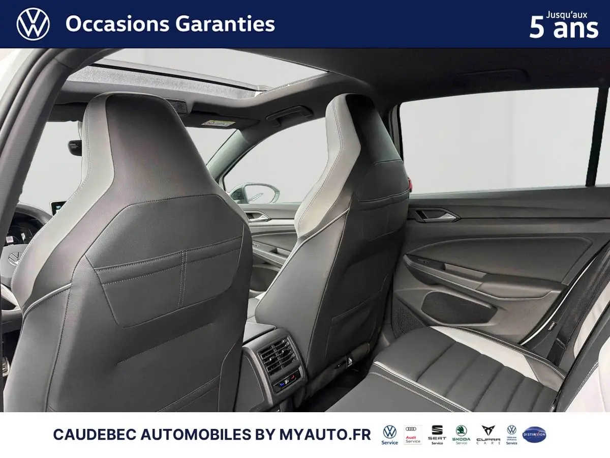 Vue intérieure arrière de la Volkswagen Golf 1.5 eHybrid blanche, mettant en valeur les sièges cuir Vienna et le toit ouvrant panoramique.