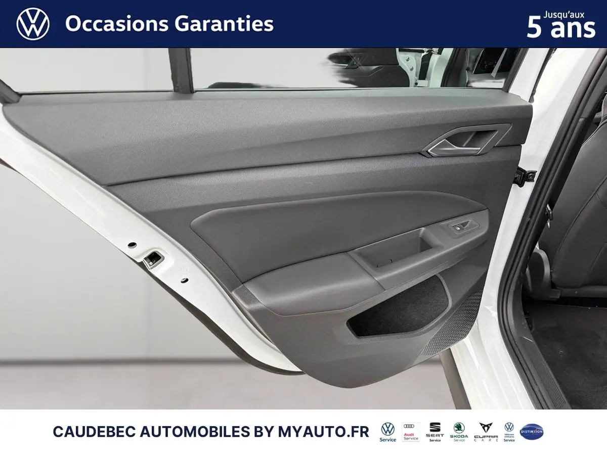 Vue rapprochée de la porte arrière gauche ouverte d’une Volkswagen Golf 1.5 eHybrid blanche, intérieur gris.