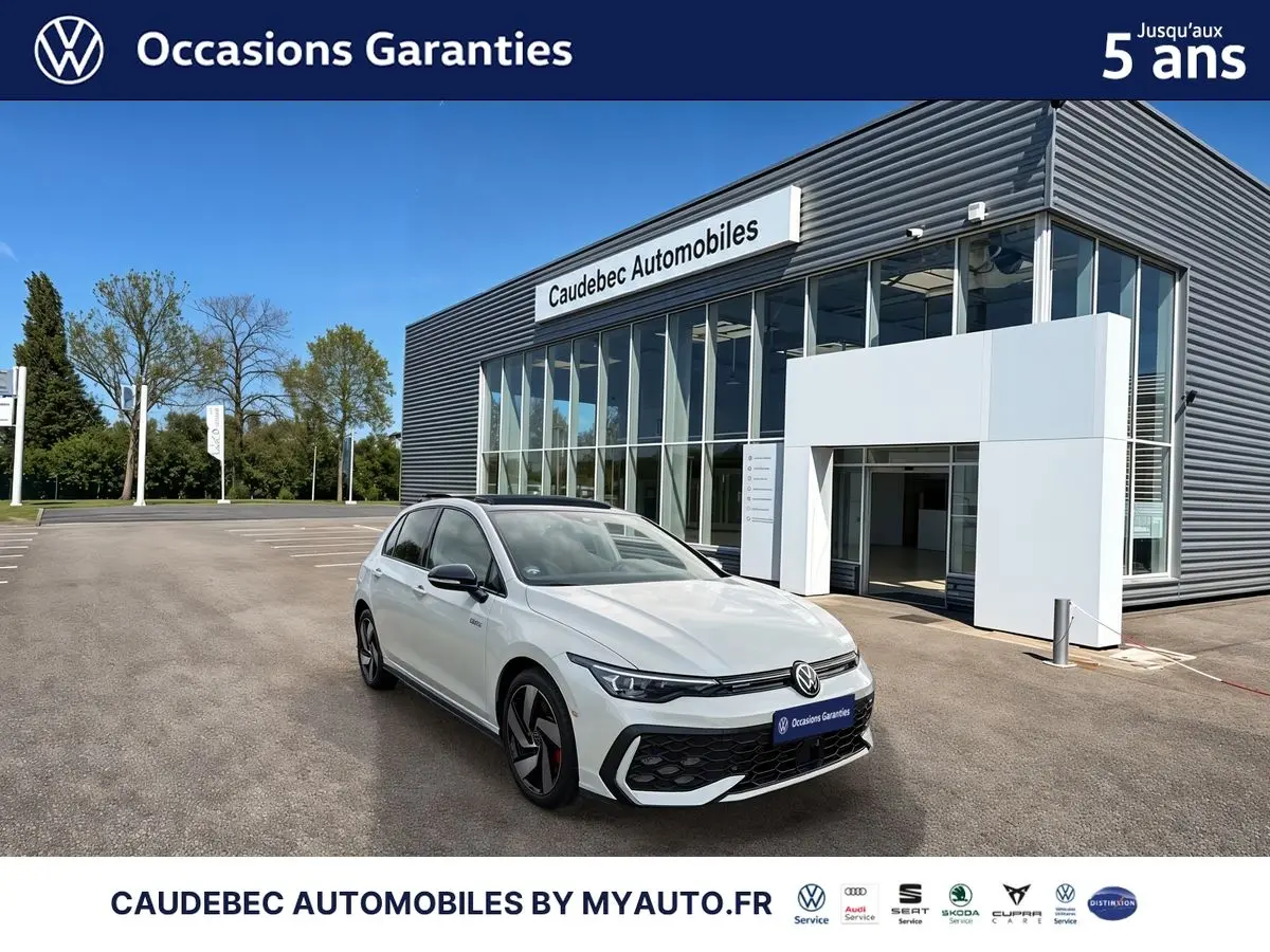 Volkswagen Golf 1.5 eHybrid blanche vue 3/4 avant, jantes alliage noir brillant, devant concession Caudebec Automobiles.