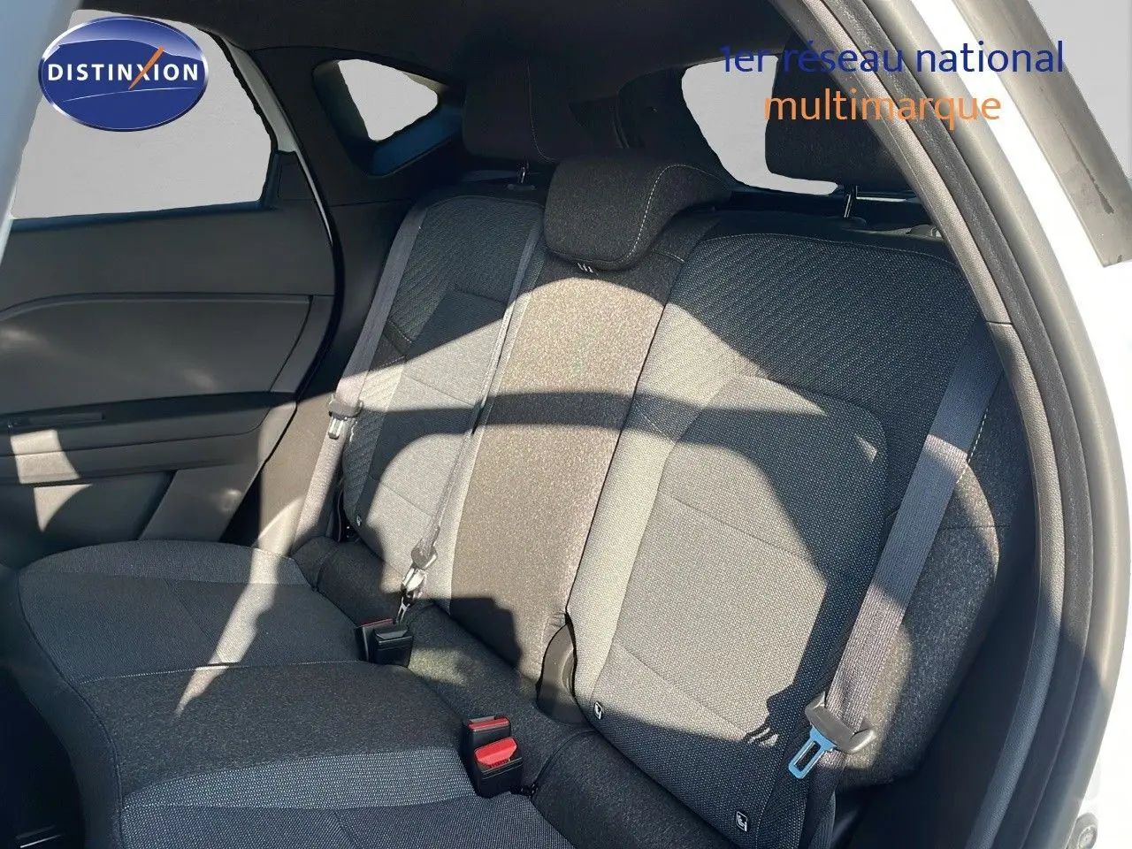 Vue intérieure sur la banquette arrière grise du Renault Captur blanc nacré avec toit gris, montrant les ceintures de sécurité.