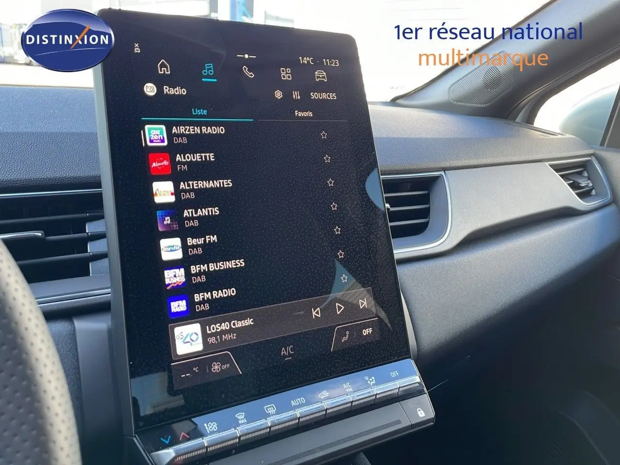 Vue intérieure du tableau de bord du Renault Captur E-Tech blanc nacré, écran tactile central affichant les stations radio.