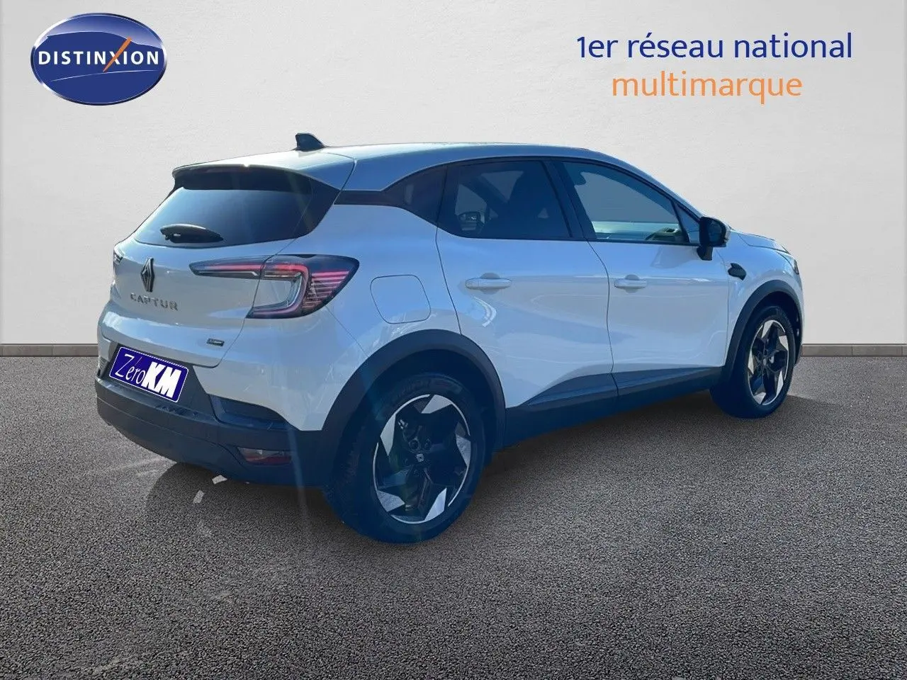 Renault Captur blanc nacré avec toit gris vu en 3/4 arrière droit, soulignant ses jantes noires et lignes modernes.