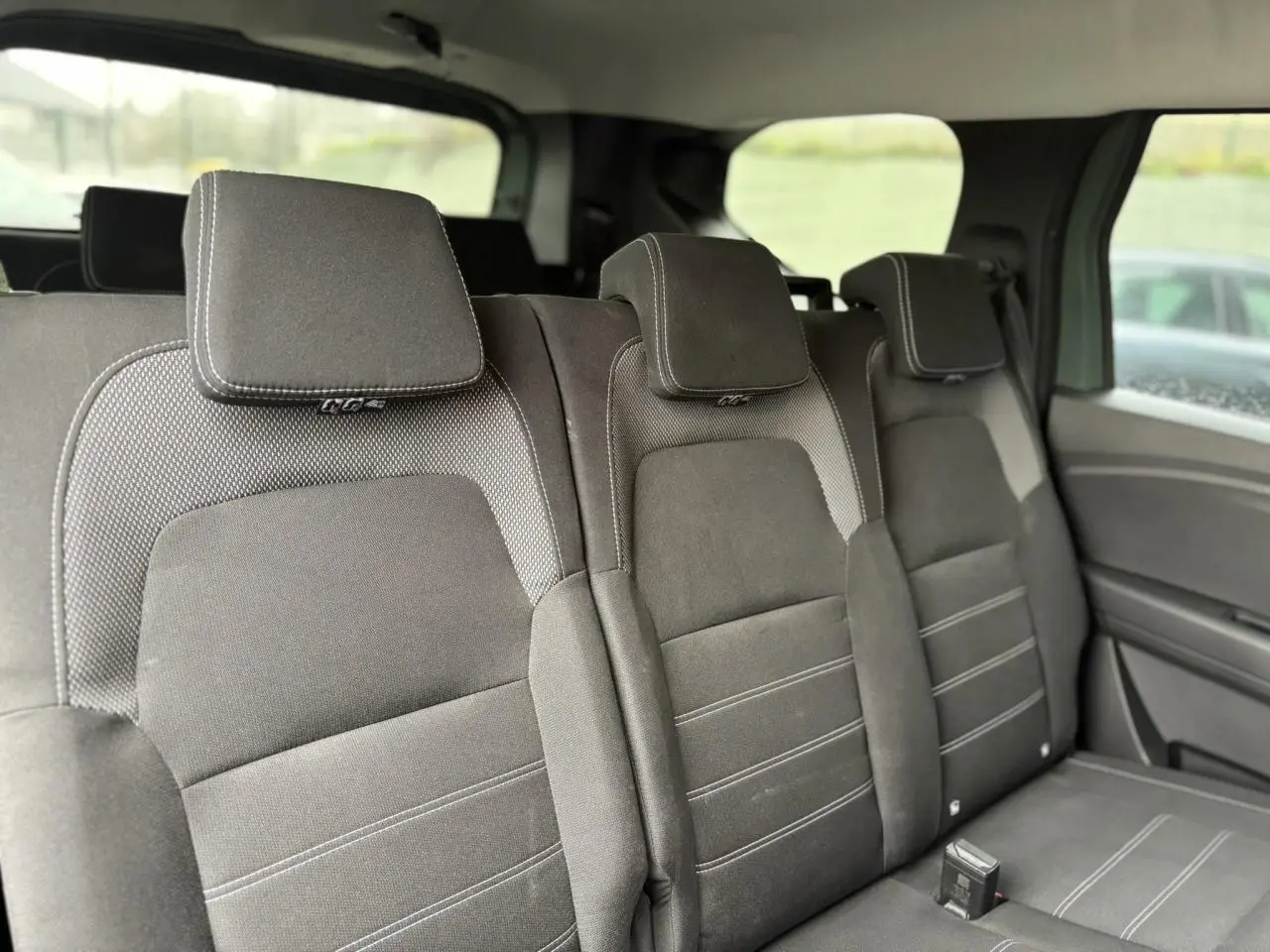 Vue intérieure des sièges arrière rabattables du Dacia Jogger 2025, finition Expression en tissu gris foncé.