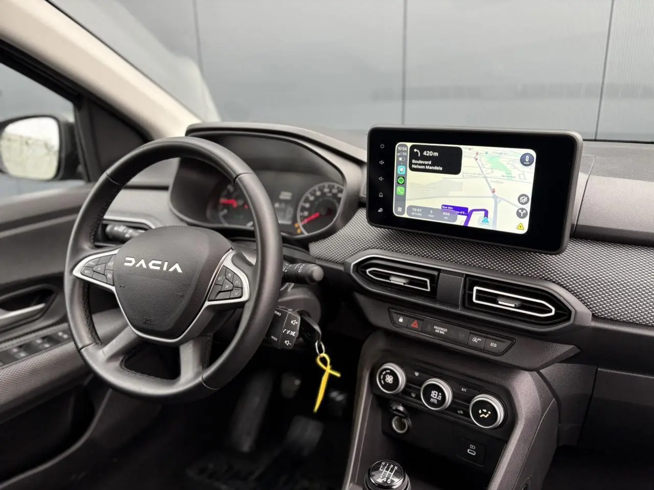 Vue intérieure du tableau de bord du Dacia Jogger 2025 avec écran tactile GPS et volant noir marqué DACIA.