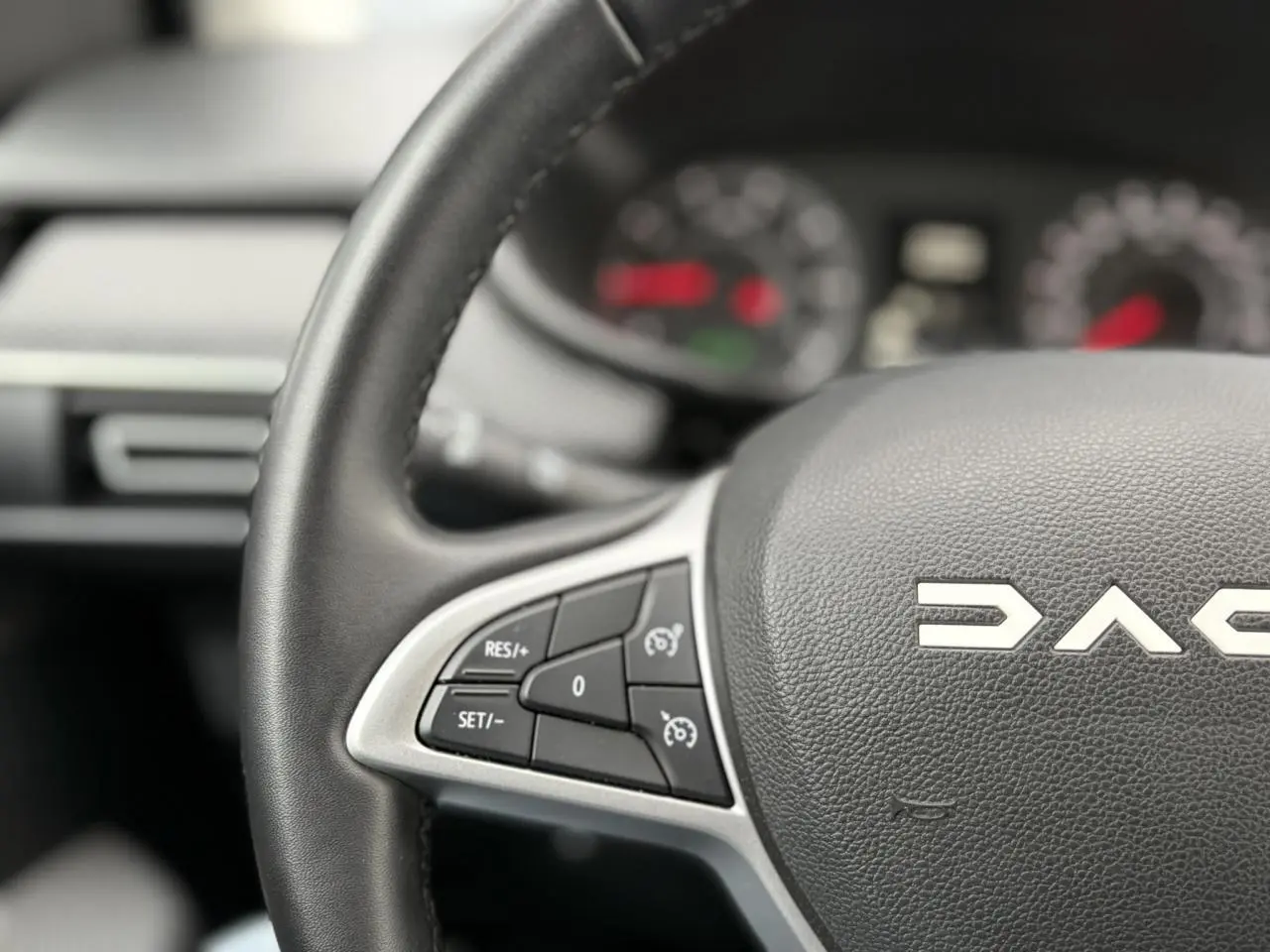Gros plan sur le volant noir du Dacia Jogger 2025 avec commandes de régulateur de vitesse visibles.