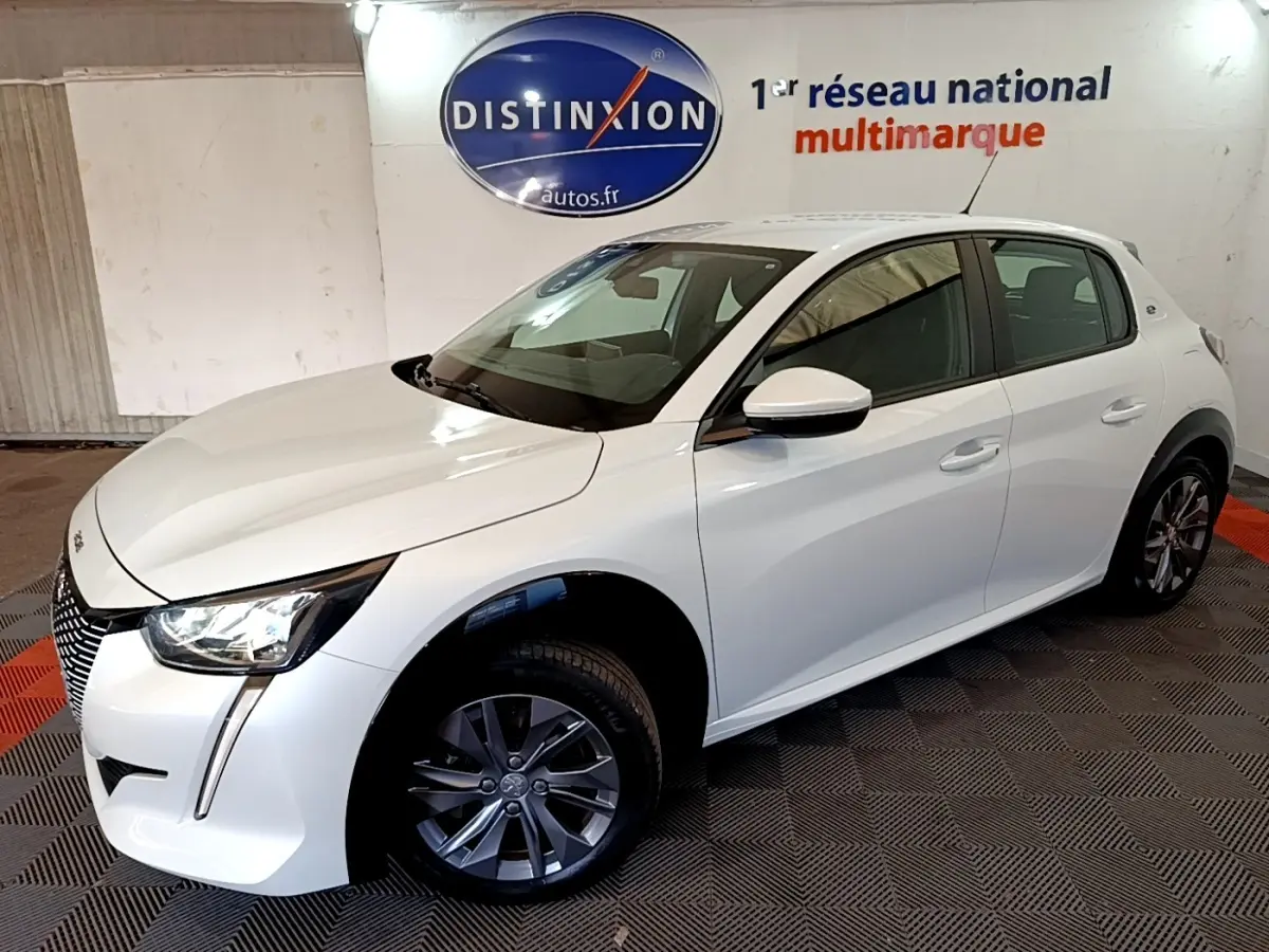 Peugeot 208 électrique blanche vue en 3/4 avant droit, avec phares LED et jantes alliage gris.