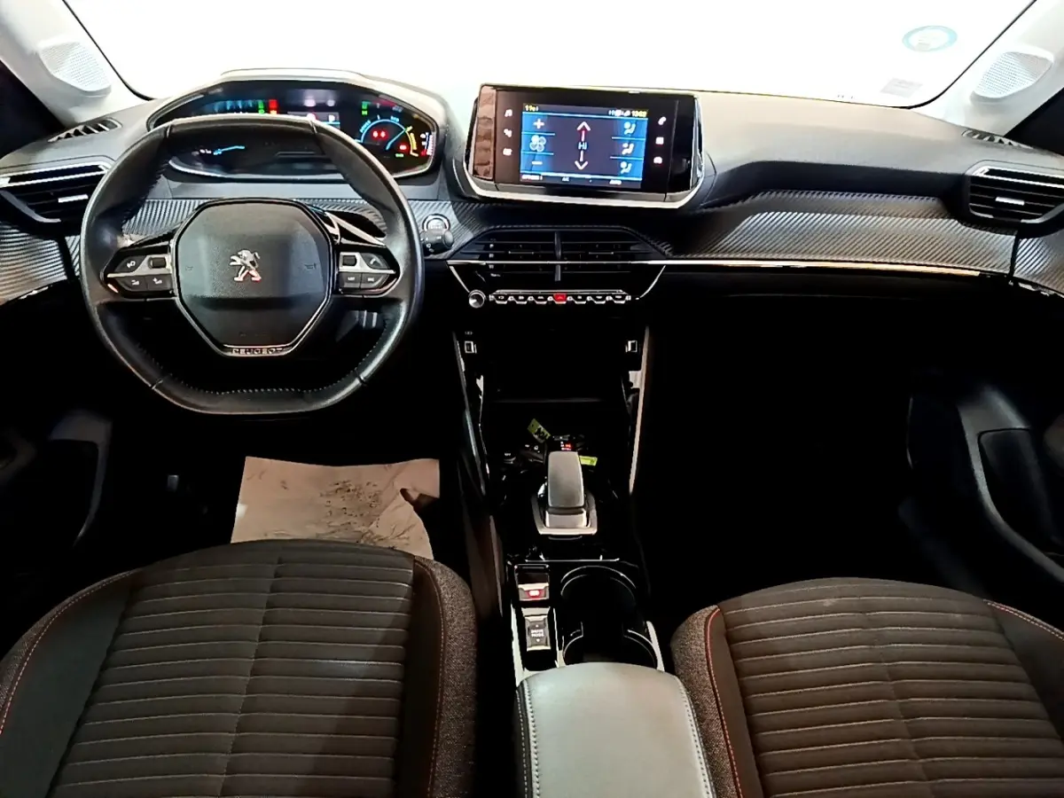 Vue intérieure avant du tableau de bord et volant cuir noir de la Peugeot 208 électrique Active Business 2021.