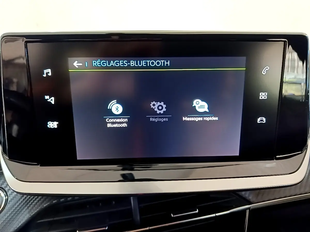 Écran tactile central affichant les réglages Bluetooth dans l'habitacle d'une Peugeot 208 blanche électrique.