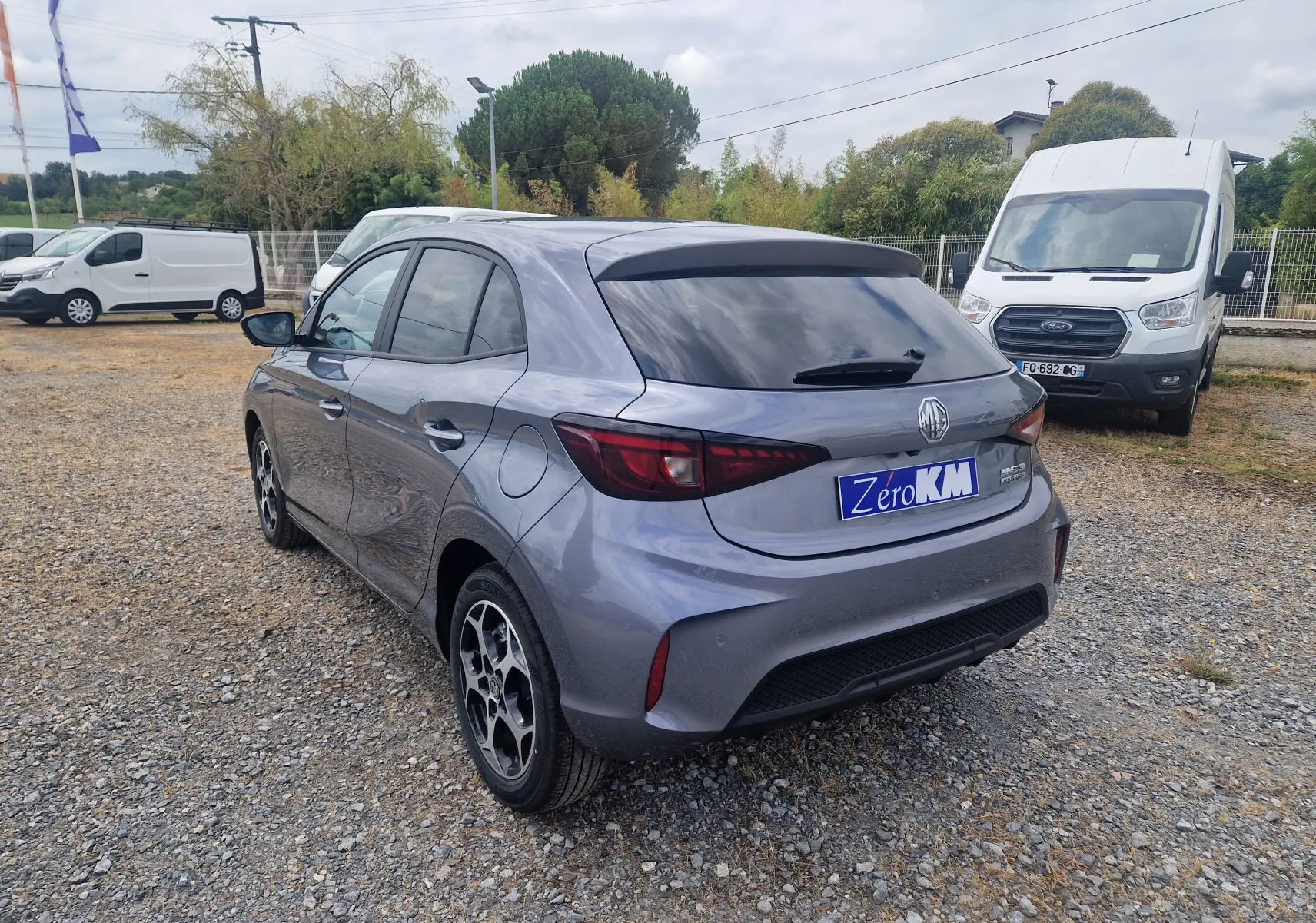Vue 3/4 arrière droite d'une MG3 1.5L Hybrid+ 195ch Luxury en gris métallisé Hampstead, avec vitres teintées et jantes stylées.