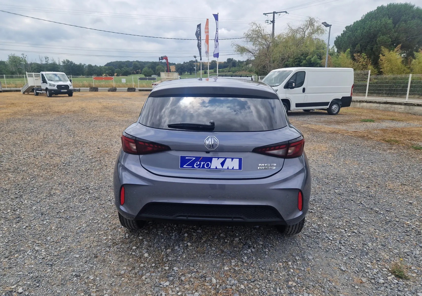 Vue arrière d'une MG3 1.5L Hybrid+ 195CH Luxury en gris Hampstead, avec vitres teintées et logo MG visible.