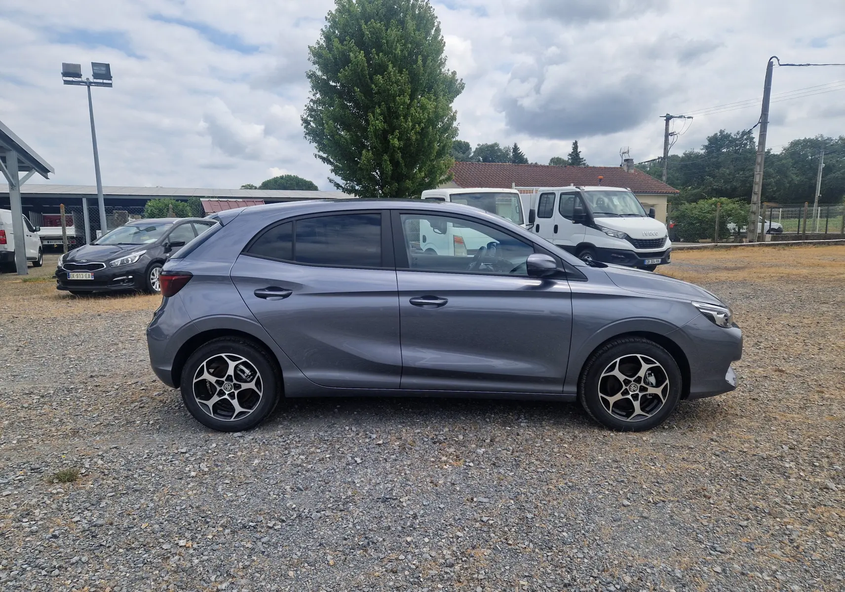 Vue de profil côté gauche d'une MG3 1.5L HYBRID+ 195CH Luxury gris métallisé Hampstead avec jantes alliage distinctives.