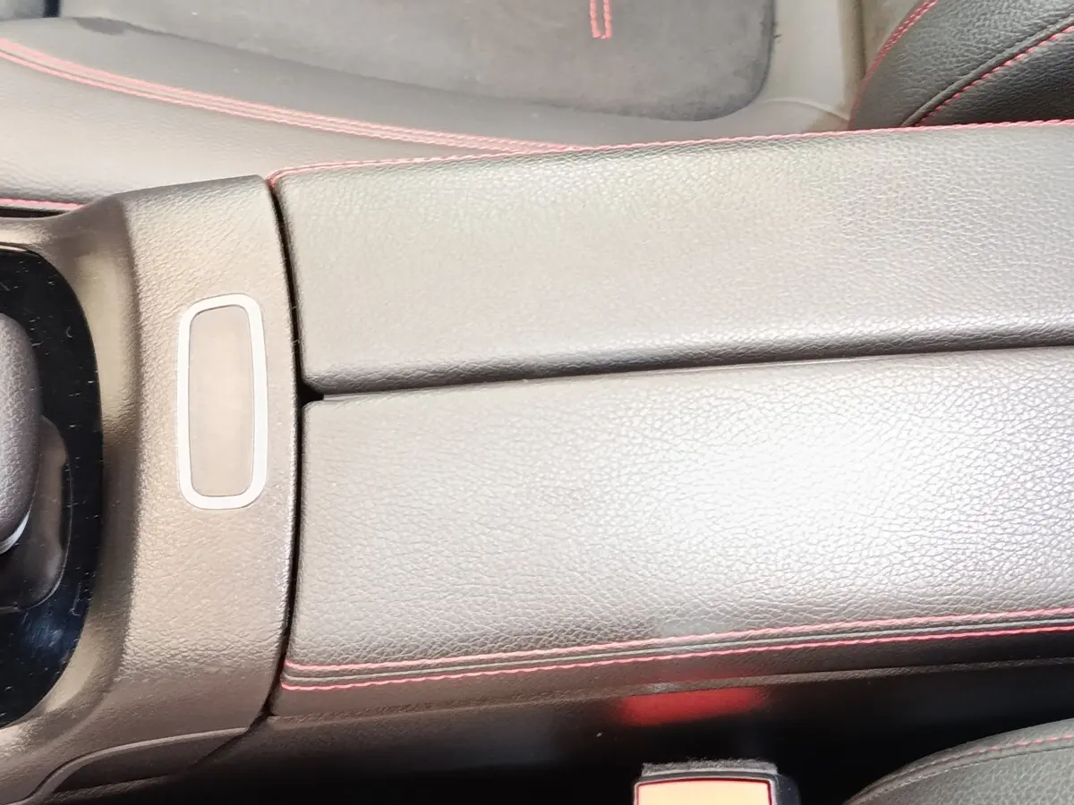 Détail de la console centrale en cuir noir avec surpiqûres rouges dans une Mercedes GLA 250 e AMG Line 2021.